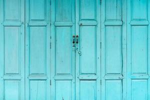 porta de madeira verde ou azul fechada. abstrato da porta da frente vintage. casa velha abandonada. textura de porta de madeira velha. foto