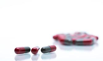foco seletivo de comprimidos cápsula vermelho-cinza sobre fundo branco, com espaço. indústria farmacêutica. produto de drogaria de farmácia. fabricação farmacêutica. conceito global de saúde farmacêutica. foto