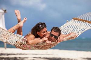 casal romântico relaxante na rede de praia foto