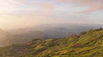 vale da montanha com raios de sol ao nascer do sol colorido no outono na ásia. bela paisagem natural com colinas nebulosas no outono foto