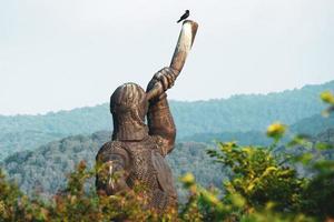 soldado gigante segurando monumento de estátua de chifre em didgori - memorial do local histórico. geórgia pontos turísticos históricos foto