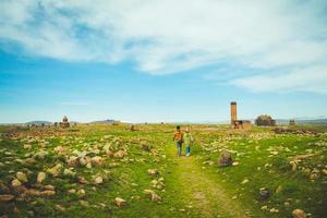 casal turco muçulmano anda pelas ruínas de ani sítio arqueológico leste da anatolia, turquia foto