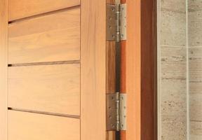 dobradiças de porta de aço inoxidável na porta de balanço de madeira foto