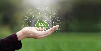 conceito de emissão de co2 nas mãos dos agricultores ícones ambientais aquecimento global desenvolvimento sustentável e negócios verdes de energia renovável ambiente limpo e amigável foto