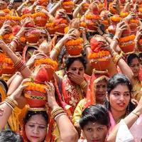 nova delhi, índia 03 de abril de 2022 - mulheres com kalash na cabeça durante o templo jagannath mangal kalash yatra, devotos hindus indianos carregam potes de barro contendo água sagrada com um coco no topo foto