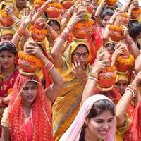nova delhi, índia 03 de abril de 2022 - mulheres com kalash na cabeça durante o templo jagannath mangal kalash yatra, devotos hindus indianos carregam potes de barro contendo água sagrada com um coco no topo foto
