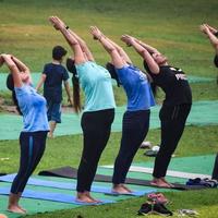 nova delhi, índia, 18 de junho de 2022 - aula de exercícios de ioga em grupo para pessoas de diferentes idades no lodhi garden park. dia internacional de ioga, grande grupo de adultos participando de uma aula de ioga lá fora no parque foto