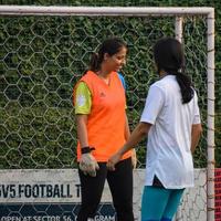 nova delhi, índia - 01 de julho de 2018 - mulheres futebolistas do time de futebol local durante o jogo no campeonato regional de derby em um campo de futebol ruim. momento quente da partida de futebol no estádio de campo verde grama foto