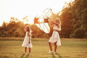 preparando a pipa. mãe e filha se divertem no campo. natureza bela foto