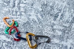 esportes radicais de risco. foto isolada de equipamento de escalada. parte do mosquetão deitado na superfície de cor branca e cinza