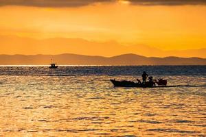 mar da tailândia no crepúsculo com navio de silhueta e pescador no mar