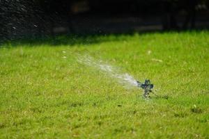 sistema de trabalho de grama de aspersão, trabalhando no campo no jardim. foto