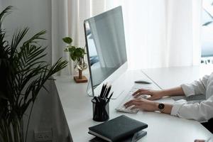 close-up de mãos de mulher digitando no teclado do computador dentro de casa. empresário trabalhando no escritório ou estudante navegando informações foto