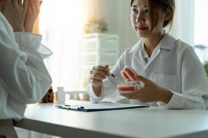 discussão de dentista e paciente sobre o tratamento planejado dos dentes no consultório da clínica odontológica - conceito de consulta ao dentista foto