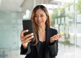 mulher de negócios asiática acenando os punhos, tem boas notícias no telefone móvel inteligente no escritório, rede de mídia social, videochamada, comunicação. foto