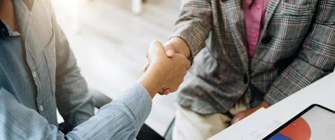 close-up de empresários apertando as mãos, terminando reunião, etiqueta empresarial, parabéns, conceito de fusão e aquisição foto