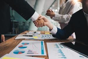 empresários apertando as mãos, terminando a reunião, etiqueta empresarial, parabéns, conceito de fusão e aquisição foto