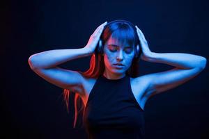 se sente bem. studio filmado em estúdio escuro com luz neon. retrato de jovem foto