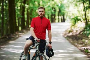 na estrada. ciclista em uma bicicleta está na floresta em dia ensolarado foto