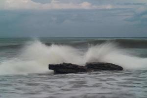 ondas batendo contra as rochas na praia durante o dia foto