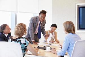 cinco empresários tendo reunião na sala de reuniões