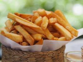 batatas fritas, batatas fritas amarelas batatas fritas crocantes na cesta de madeira, lanche delicioso foto