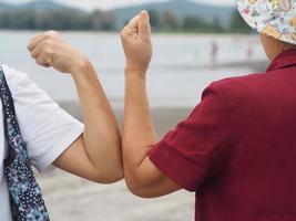 duas mulheres apertos de mão alternativos saudação de cotovelo na situação de uma epidemia covid 19, coronavírus novo distanciamento social normal foto