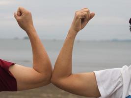 duas mulheres apertos de mão alternativos saudação de cotovelo na situação de uma epidemia covid 19, coronavírus novo distanciamento social normal foto