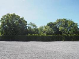 estacionamento polvilhado com cascalho arbusto verde árvore céu azul fundo da natureza foto