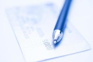 cartão de crédito no computador para comércio eletrônico com uma caneta foto