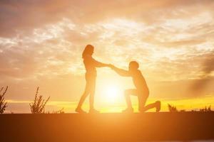 uma silhueta de um homem e uma mulher de mãos dadas, caminhando juntos. foto