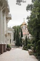 rua estreita que leva a uma igreja cristã com cúpula dourada foto