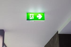 sinal de saída de emergência de incêndio no fundo da parede dentro do prédio. conceito de segurança foto