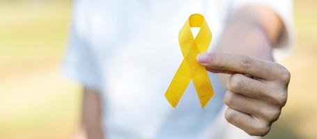 prevenção do suicídio, sarcoma, osso, bexiga, mês de conscientização do câncer infantil, fita amarela para apoiar pessoas vivas e doentes. saúde infantil e conceito de dia mundial do câncer foto