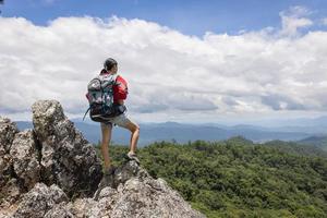 menina na montanha olhe para o belo vale na neblina no verão. paisagem com mulheres jovens desportivas, caminhadas, viagens e turismo. foto