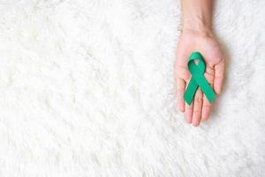 setembro mês de conscientização do câncer de ovário, mulher segurando a cor da fita azul-petróleo para apoiar as pessoas que vivem e doenças. conceitos de saúde e dia mundial do câncer foto