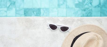 óculos de sol brancos e chapéu perto da piscina no hotel de luxo. conceito de viagens de verão, férias, férias e fim de semana foto