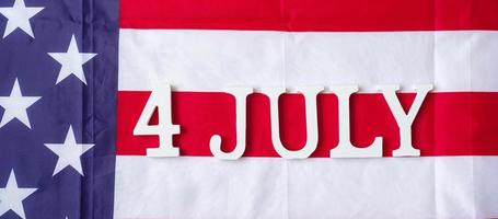 texto de quatro de julho no fundo da bandeira dos estados unidos da américa. feriado dos eua de conceitos de independência e celebração foto