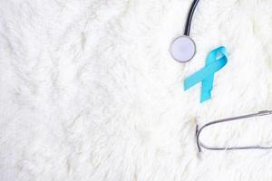 conscientização do câncer de próstata de novembro, fita azul clara com estetoscópio para apoiar pessoas vivas e doentes. dia do diabetes, homens internacionais e conceito do dia mundial do câncer foto