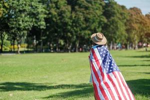 mulher viajando com bandeira dos estados unidos da américa no parque ao ar livre. feriado dos eua de veteranos, memorial, independência e conceito de dia do trabalho foto