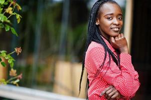 bonito tranças negócio afro-americano senhora brilhante mandão pessoa amigável desgaste escritório camisa vermelha. foto