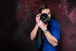 retrato de estúdio de homem elegante fotógrafo profissional com câmera, usar camisa azul e gravata. foto