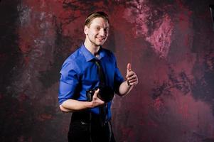 retrato de estúdio de homem elegante fotógrafo profissional com câmera, usar camisa azul e gravata. foto