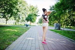 garota esporte usar calção branco e camisa com patins no parque. foto