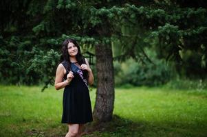 retrato de menina linda usar preto na festa de despedida, posou no parque. foto