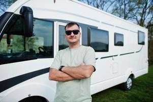 homem de óculos de sol viaja na van de campista rv motorhome. foto