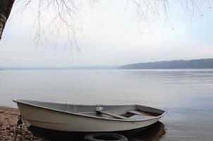 barco na margem do lago, minimalismo. natureza adormecida foto