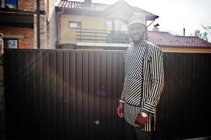 retrato de homem afro-americano preto elegante no chapéu e óculos de sol contra a cerca. foto