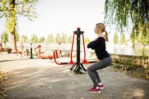 jovem tem o treinamento e exercício ao ar livre em simuladores de rua. esporte, fitness, conceito de treino de rua. foto