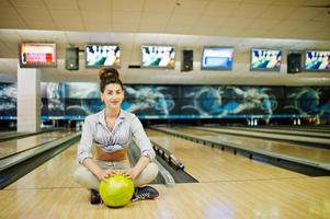 menina com bola de boliche no beco jogou no clube de boliche. foto